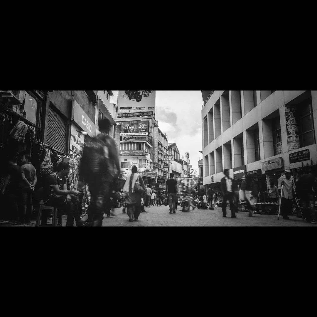 Pedestrians blur through the market lane